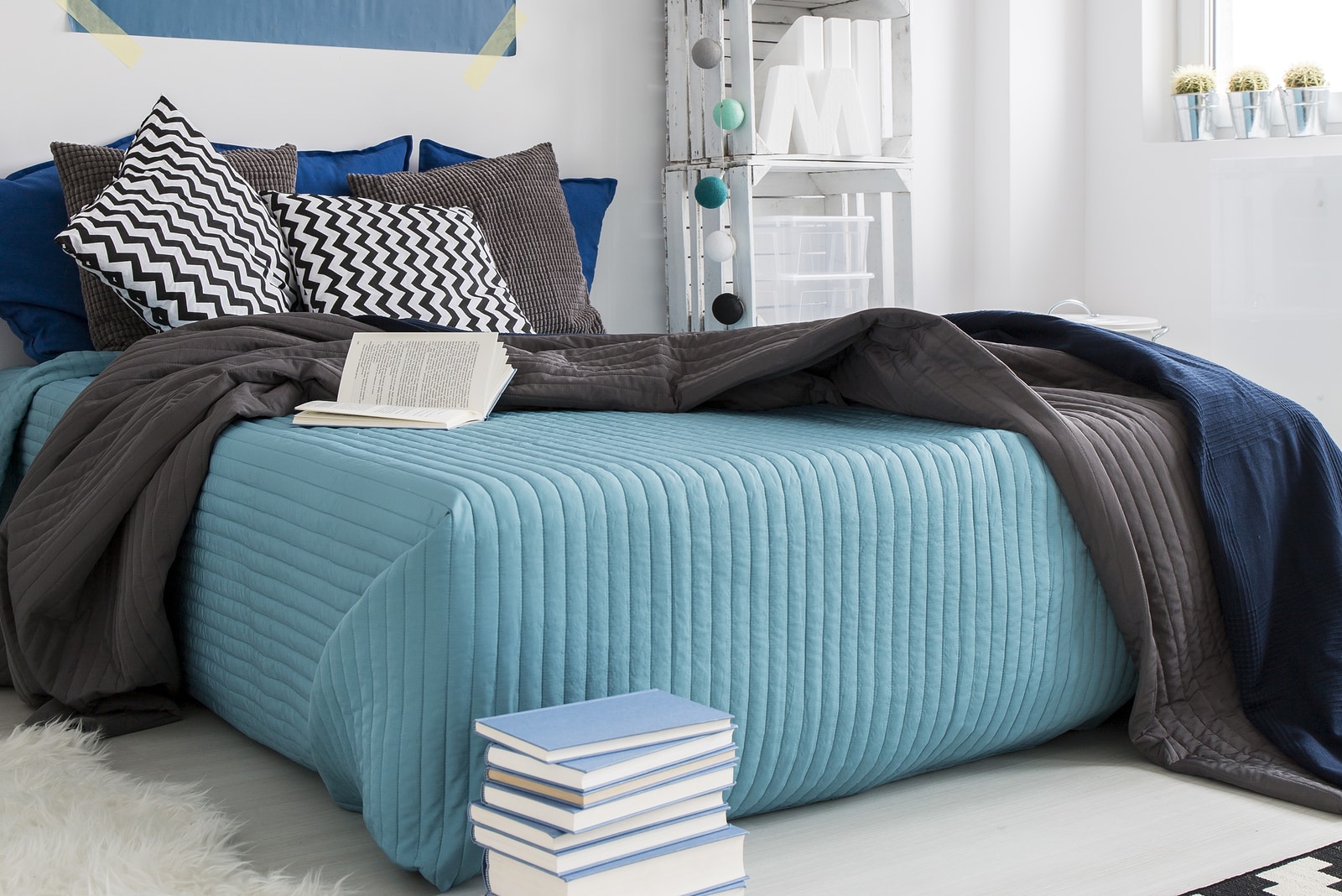 Comfortable bed in cozy modern blue bedroom